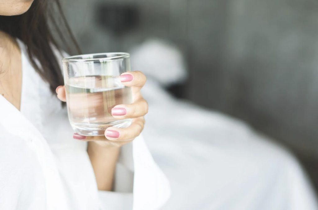 寝起きで水を飲む女性